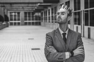 Arroganter Mensch mit einer Krone auf dem Kopf SW