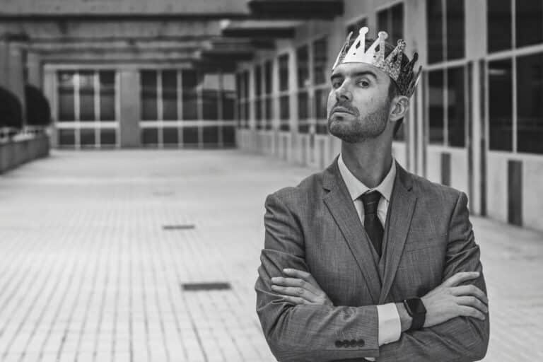 Arroganter Mensch mit einer Krone auf dem Kopf SW