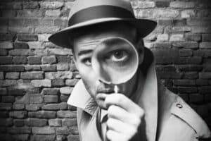 Detektiv schaut durch eine Lupe SW