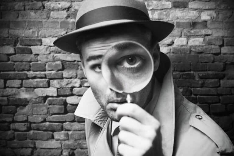 Detektiv schaut durch eine Lupe SW